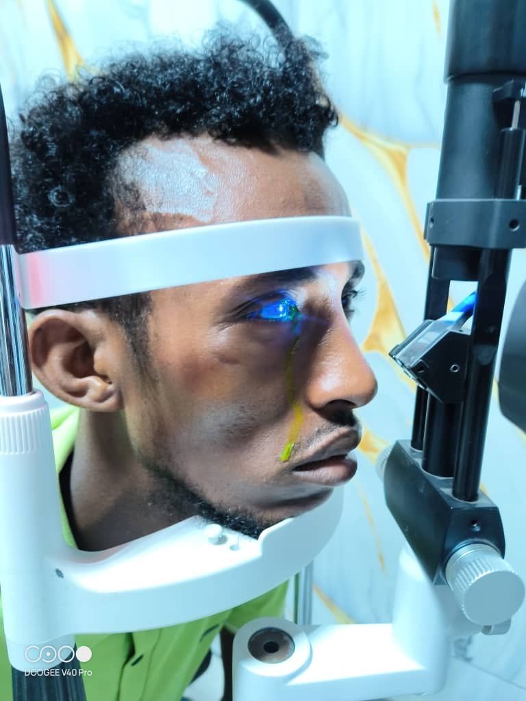 A photo of a Somalian man being given an eye exam