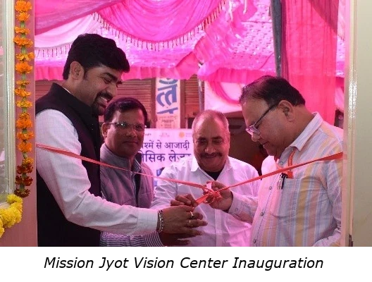 A photo of Mission Jyot Vision Centre Inauguration ceremony showing four people smiling and cutting a ribbon across the door of the vision center.