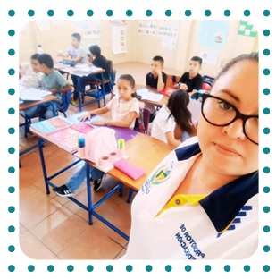 Photo of a teacher in Guatemala with students behind her